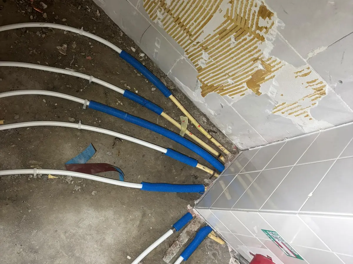 Aanleg van nieuwe waterleidingen in de vloer voorafgaand aan een renovatie.